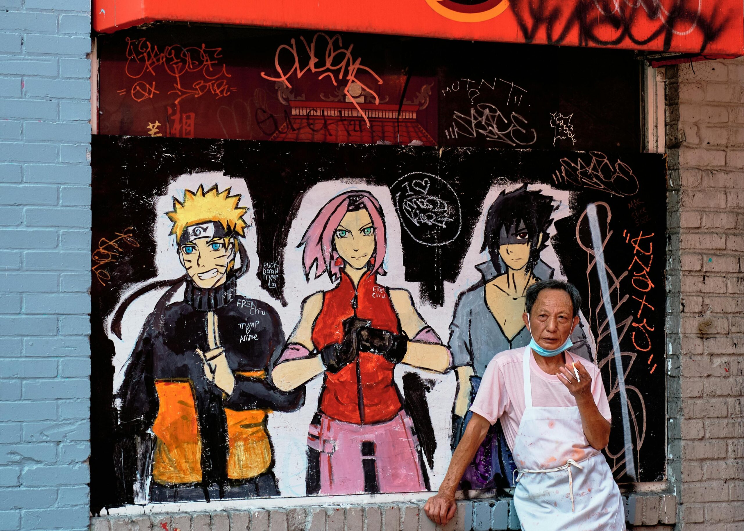 Urban scene in Seattle with anime graffiti and a senior man in front.